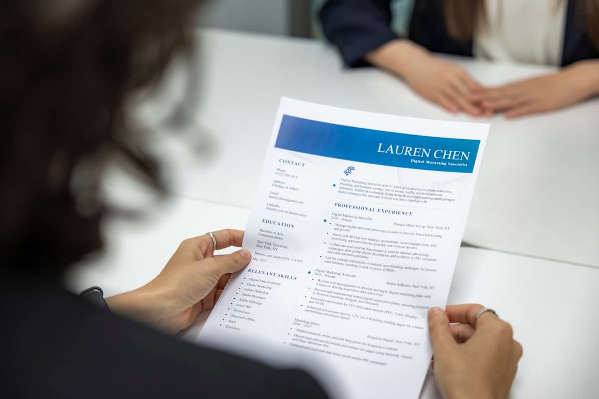 A person reviewing a printed resume document at a table