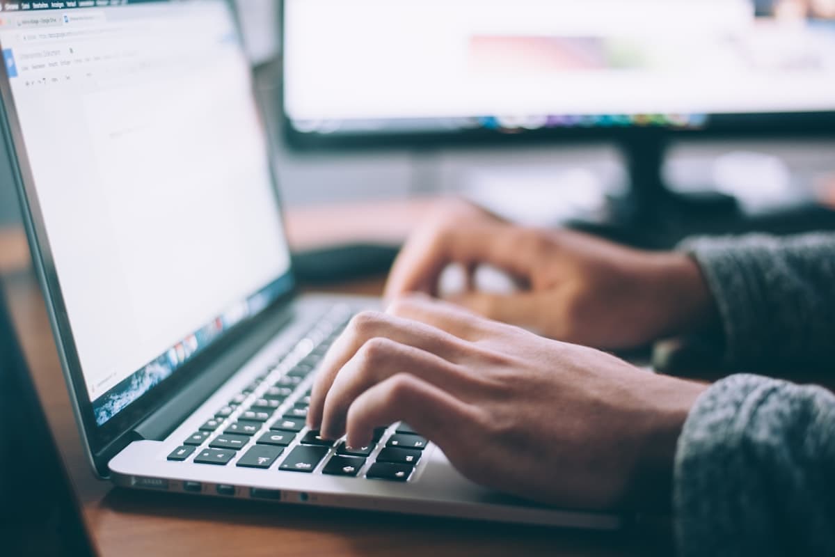 Person typing on a laptop with a document editor open, representing writing and converting a document