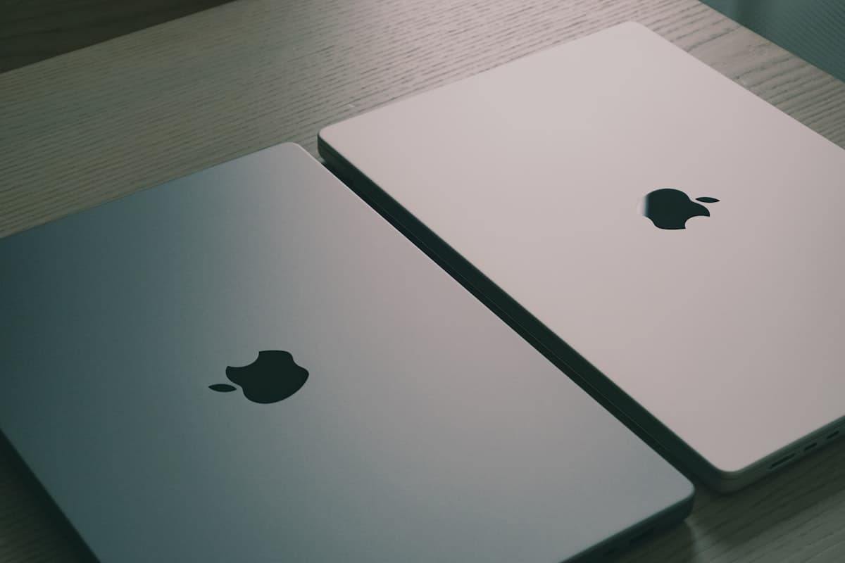 Two laptops side by side on a desk, representing a tool comparison